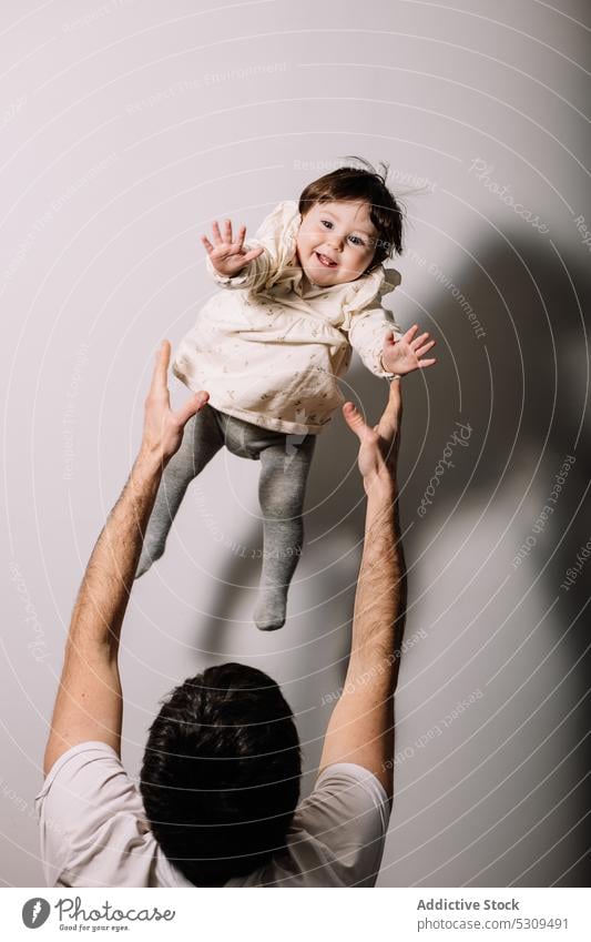 Unbekannter Mann hebt süßes kleines Mädchen auf Händen Vater Kind Tochter anheben Elternschaft bezaubernd Liebe Kindheit Zusammensein positiv niedlich Glück