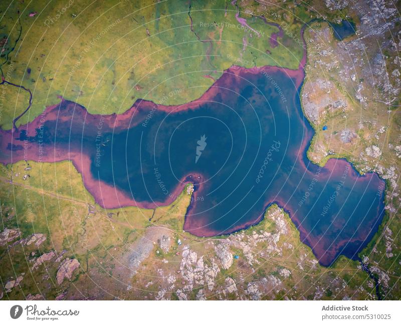 Luftaufnahme eines hellen Sees inmitten eines grünen Tals Wasser Landschaft Natur Gras Teich Stein Umwelt farbenfroh malerisch Pyrenäen Huesca Spanien