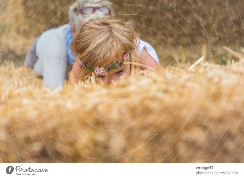 Weiter geht die Suche nach der Nadel im Heuhaufen Thementag Stroh Strohballen Kind Mädchen Außenaufnahme Sommer Sprichwort Suchaktion Oma Omi Großmutter