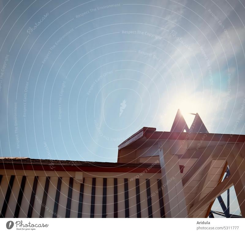 Strandhäuschen aus Holz mit Streifen, Himmel und Sonnenlicht Ausschnitt Haus Holzhaus Strandhaus Gegenlicht Licht Dach weiß Urlaub Ferien