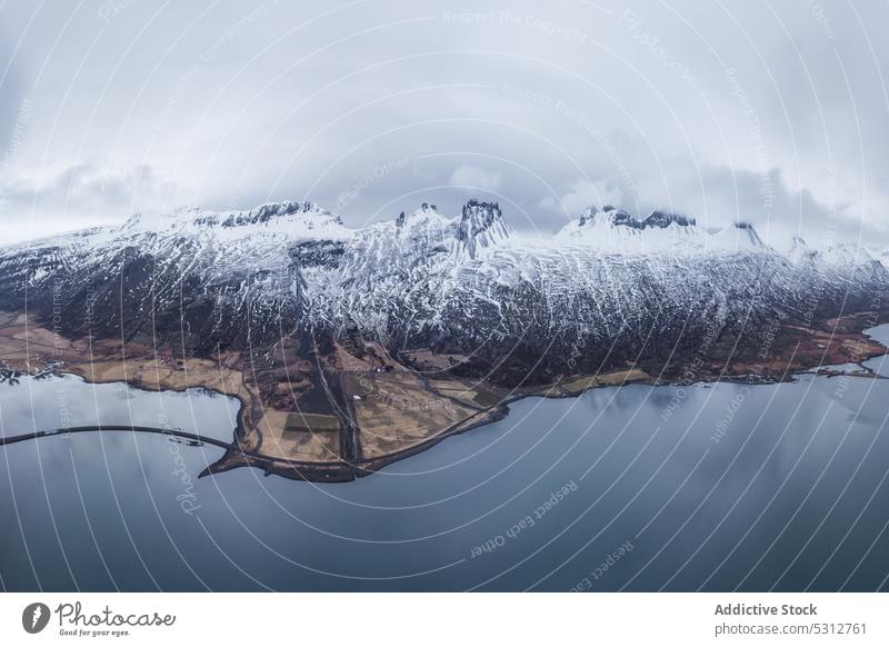 Verschneiter Gebirgskamm unter bewölktem Himmel Island Berge u. Gebirge See Winter Schnee Ambitus Landschaft Wasser kalt Kamm Natur Teich malerisch Saison