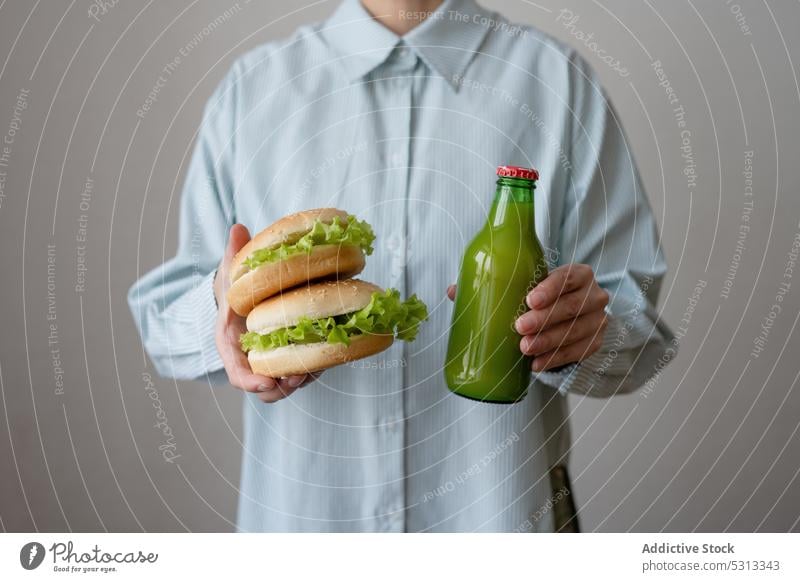 Unbekannte Person mit vegetarischen Burgern und Flaschensaft Saft Veganer Vegetarier trinken grün Getränk Entzug Gesundheit appetitlich Hamburger lecker Hand