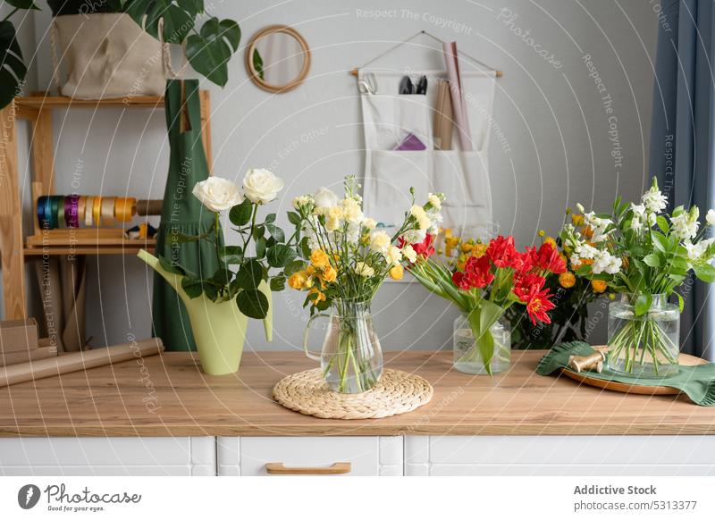 Helle Blumen in Vase auf Tisch Blumenstrauß geblümt Zusammensetzung Blüte frisch Blütezeit Haufen Pflanze natürlich Dekor Glas Flora Ordnung