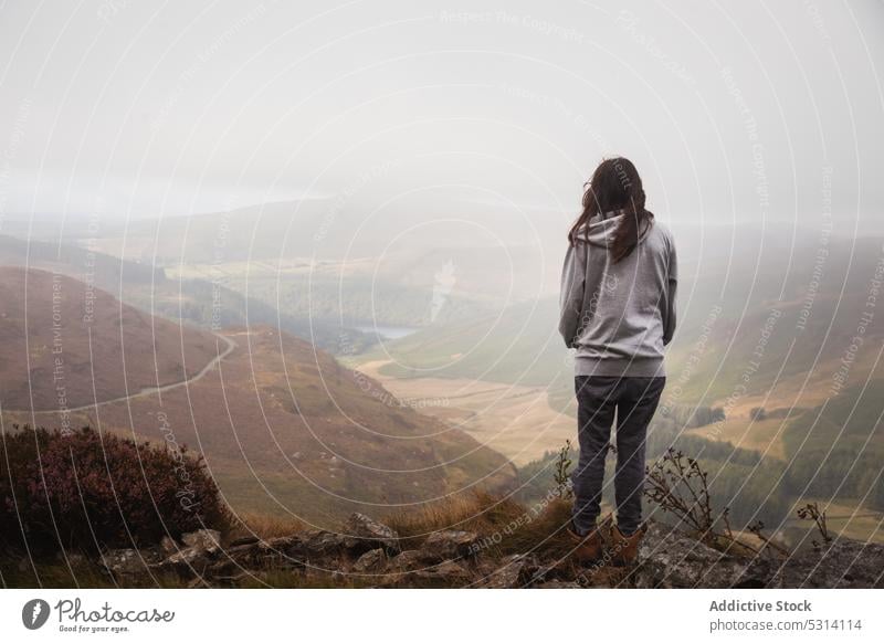 Frau steht auf dem Gipfel eines Berges und bewundert die Aussicht auf den Boden Reisender Tal bewundern Hügel Natur See Umwelt Feld Berge u. Gebirge beobachten