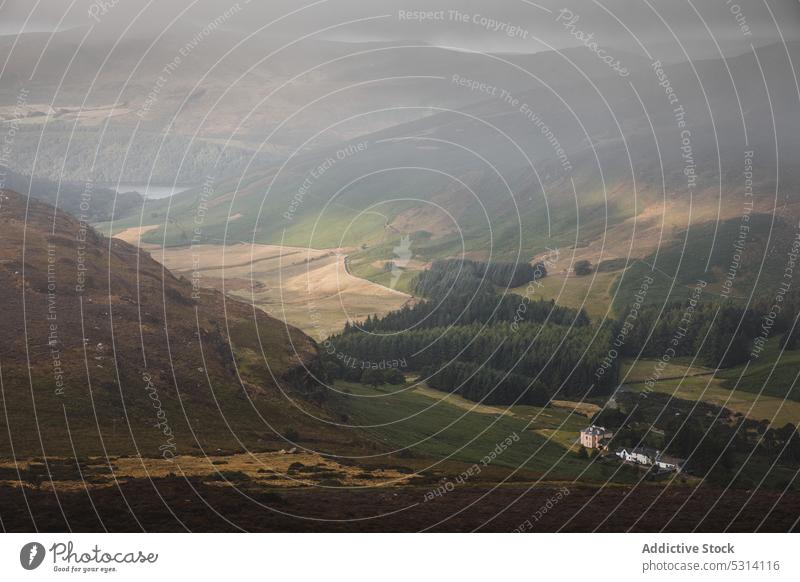 Malerische Aussicht auf Berge mit grünen Bäumen und See Landschaft Natur Feld Berge u. Gebirge Tal Baum Umwelt Meer malerisch Himmel Gelände Hochland bewundern