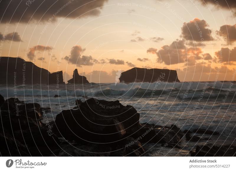 Steiniger Strand mit bewölktem Himmel bei Sonnenuntergang MEER Küste felsig Natur Ufer winken Abend malerisch Meereslandschaft wolkig Dämmerung rau