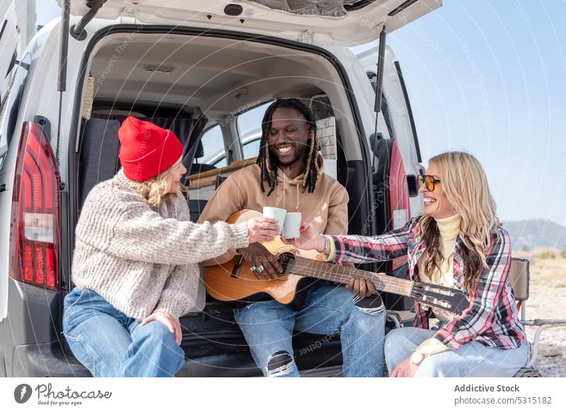 Eine Gruppe von Freunden hat Spaß mit der Gitarre Zusammensein spielen Freundschaft Musik Lächeln heiter Instrument Glück Kleintransporter Sommer Freude Natur