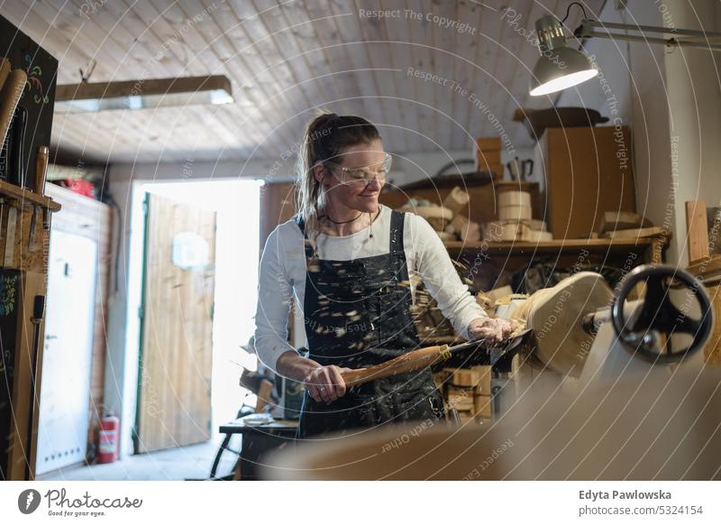 Handwerkerin beim Schnitzen von Holz in einer Schreinerei echte Menschen Holzwerkstatt Zimmerer Unternehmer Kompetenz Werkstatt Kreativität Herstellung Hobby