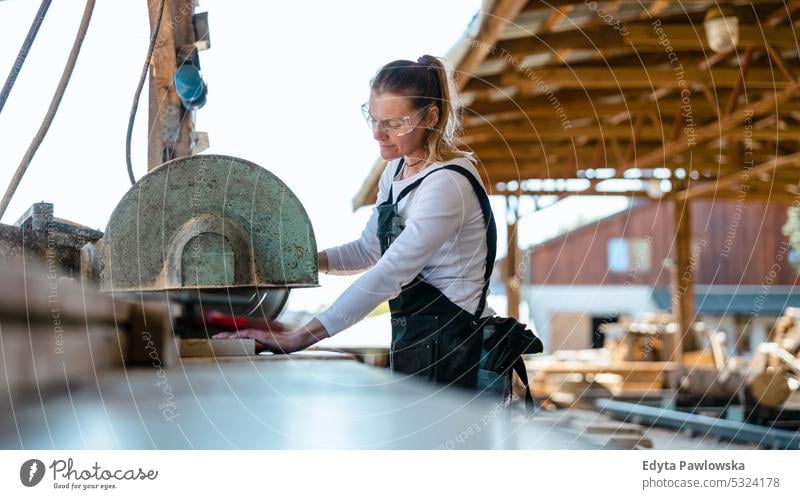 Zimmermann schneidet Brett mit Kreissäge in einem Sägewerk echte Menschen Holzwerkstatt Zimmerer Unternehmer Kompetenz Werkstatt Handwerker Kreativität