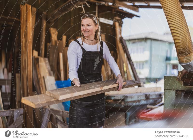 Frau arbeitet mit Holzbrettern in einem Sägewerk echte Menschen Holzwerkstatt Zimmerer Unternehmer Kompetenz Werkstatt Handwerker Kreativität Herstellung Hobby