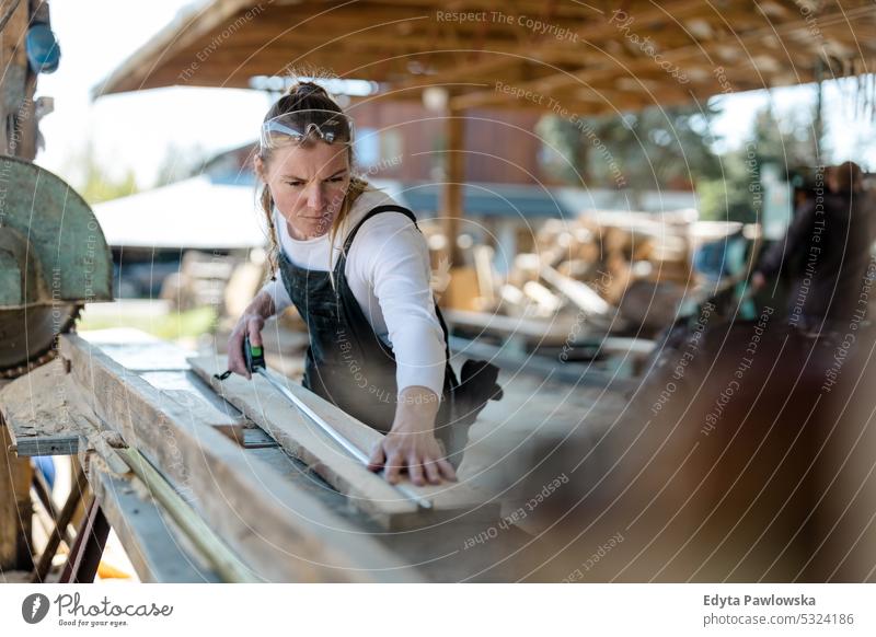 Frau arbeitet mit Holzbrettern in einem Sägewerk echte Menschen Holzwerkstatt Zimmerer Unternehmer Kompetenz Werkstatt Handwerker Kreativität Herstellung Hobby