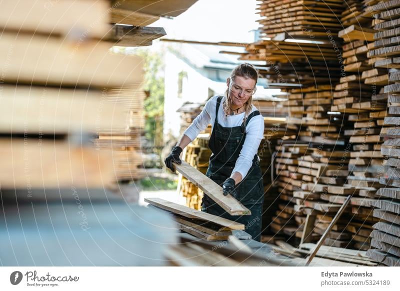 Frau arbeitet mit Holzbrettern in einem Sägewerk echte Menschen Holzwerkstatt Zimmerer Unternehmer Kompetenz Werkstatt Handwerker Kreativität Herstellung Hobby