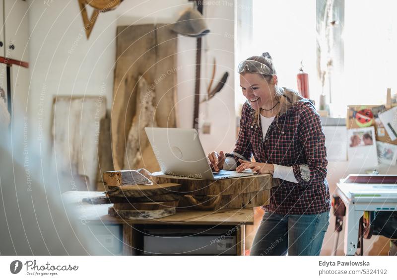 Schreinerin mit Laptop in einer Schreinerei echte Menschen Holzwerkstatt Zimmerer Unternehmer Kompetenz Werkstatt Handwerker Kreativität Herstellung Hobby