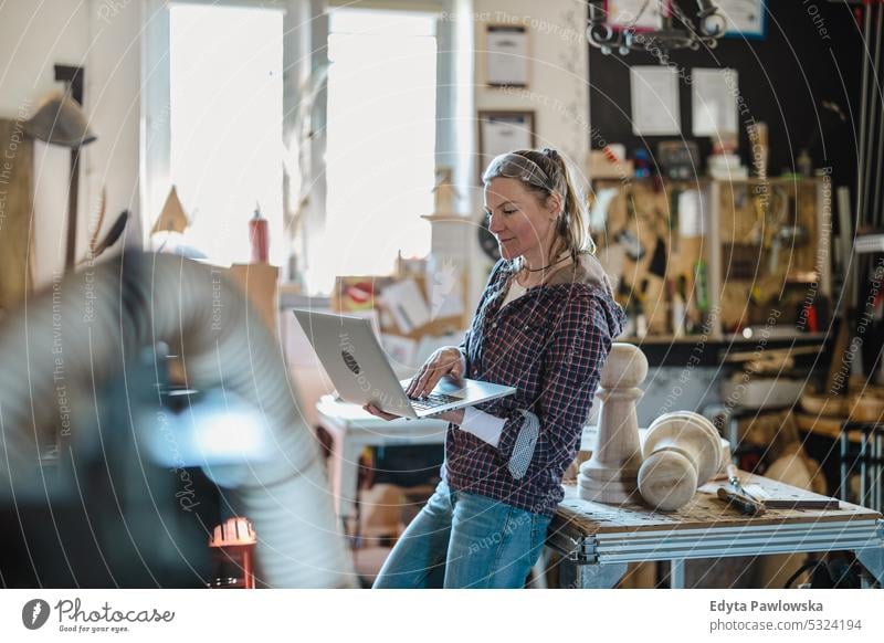 Schreinerin mit Laptop in einer Schreinerei echte Menschen Holzwerkstatt Zimmerer Unternehmer Kompetenz Werkstatt Handwerker Kreativität Herstellung Hobby