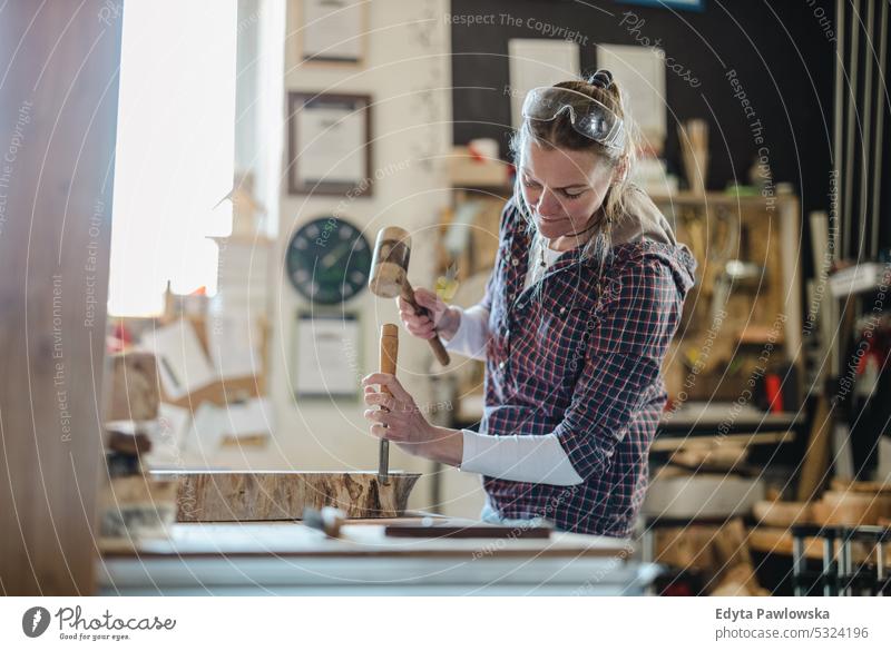 Handwerkerin bei der Arbeit mit Holz in einer Schreinerei echte Menschen Holzwerkstatt Zimmerer Unternehmer Kompetenz Werkstatt Kreativität Herstellung Hobby