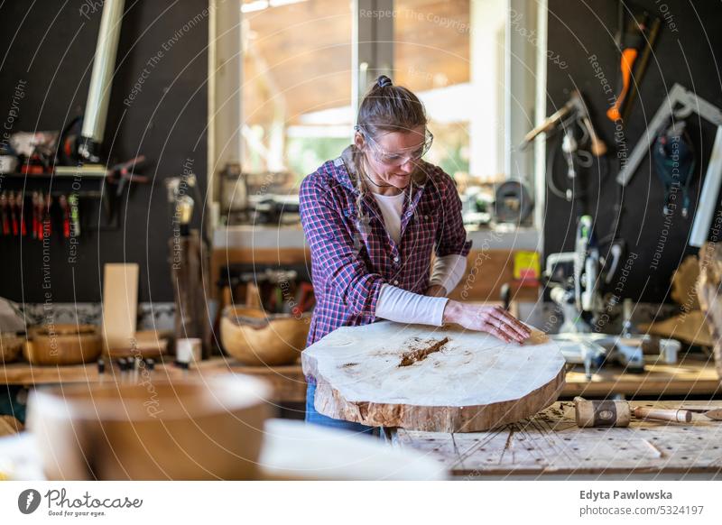 Handwerkerin bei der Arbeit mit Holz in einer Schreinerei echte Menschen Holzwerkstatt Zimmerer Unternehmer Kompetenz Werkstatt Kreativität Herstellung Hobby