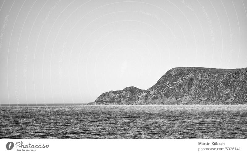 Blick vom Meer auf das Westkap in Norwegen bei Sonnenschein in schwarz-weiß. Westkap. Fjord MEER atlantisch Wellen Himmel Cloud Landschaft Berge u. Gebirge