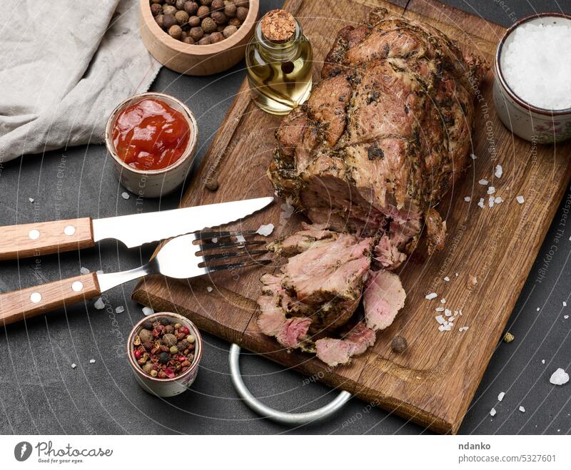 Gebackener Schweinekragen mit Gewürzen auf einem Holzbrett, leckeres und saftiges Fleisch gebacken Schweinehalsband hölzern Holzplatte gebraten