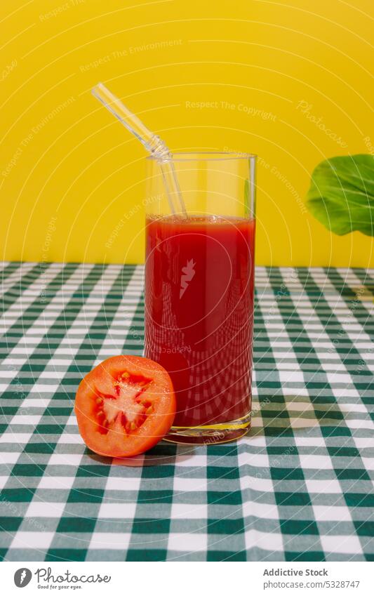 Glas erfrischender Tomatensaft mit Strohhalm Saft kariert umweltfreundlich keine Verschwendung Tischwäsche hell reif Hälfte Cocktail natürlich wiederverwenden