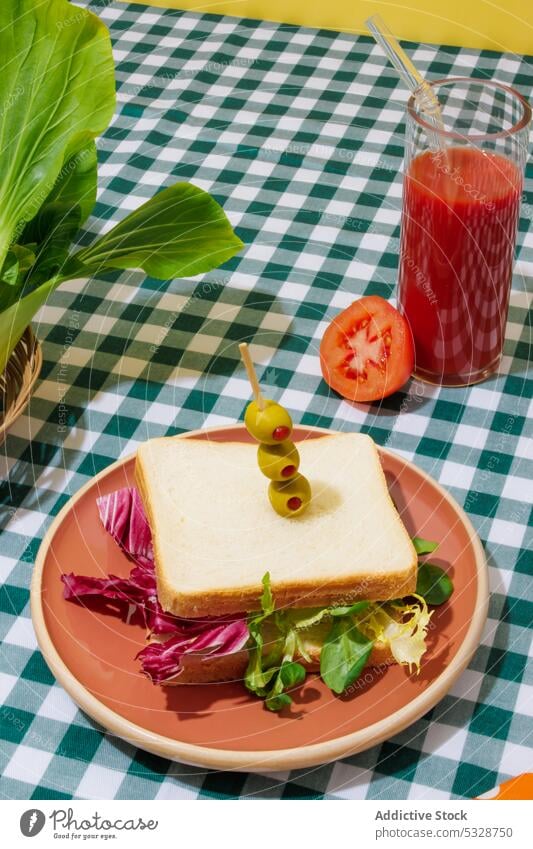 Leckerer Smoothie und gesundes Sandwich auf kariertem Tischtuch Belegtes Brot Salatbeilage Tomate Saft gesunde Ernährung Erfrischung Gesundheit Lebensmittel