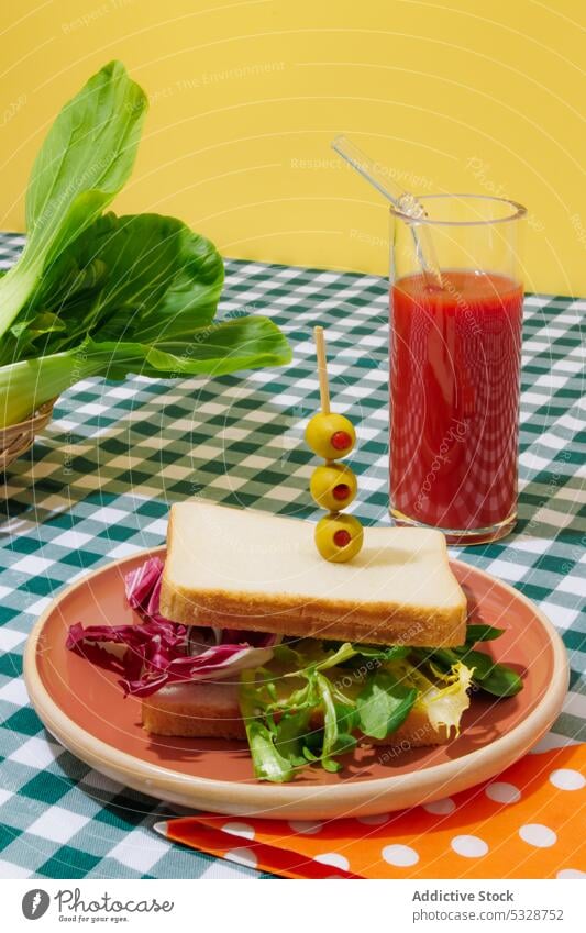 Leckerer Smoothie und gesundes Sandwich auf kariertem Tischtuch Belegtes Brot Salatbeilage Tomate Saft gesunde Ernährung Erfrischung Gesundheit Lebensmittel