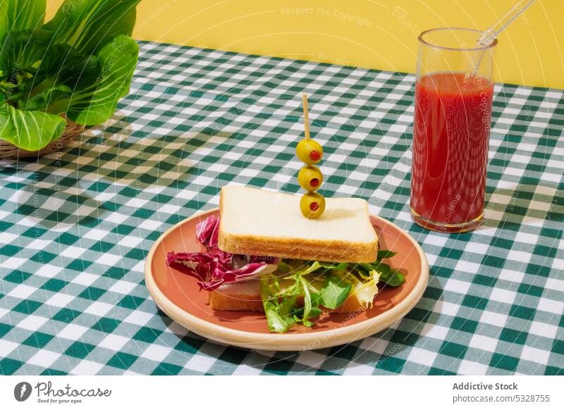 Leckerer Smoothie und gesundes Sandwich auf kariertem Tischtuch Belegtes Brot Salatbeilage Tomate Saft gesunde Ernährung Erfrischung Gesundheit Lebensmittel