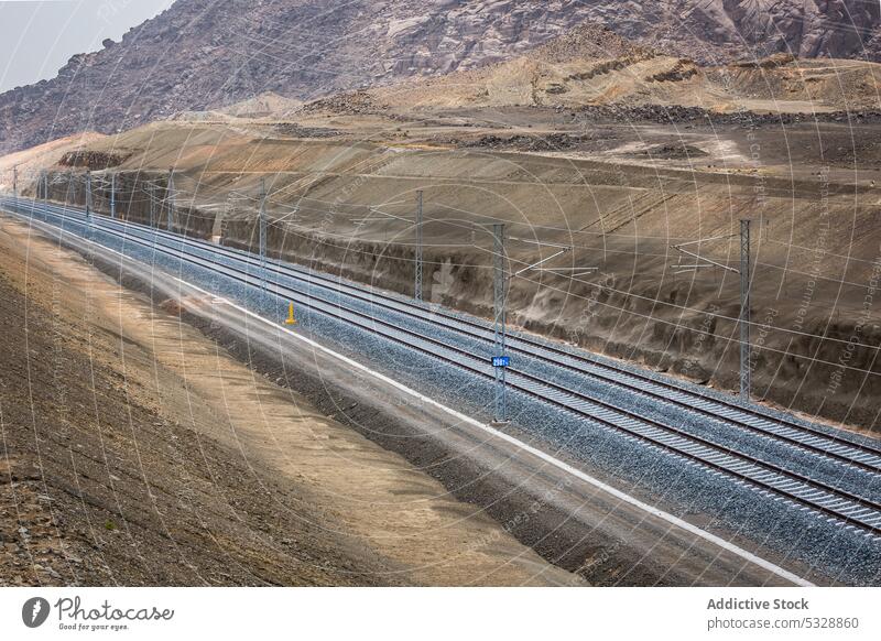 Doppelspurige Gleise mit Stromleitungen Eisenbahn Berge u. Gebirge Entwicklung Landschaft Hügel Natur Hochland trocknen malerisch Bahn Durchgang Schiene Linie