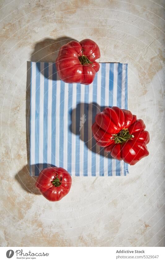 Reife Tomaten auf einem Tischtuch über einer ebenen Fläche rot frisch kariert reif Gesundheit Tischwäsche geschmackvoll Gemüse organisch Bestandteil natürlich