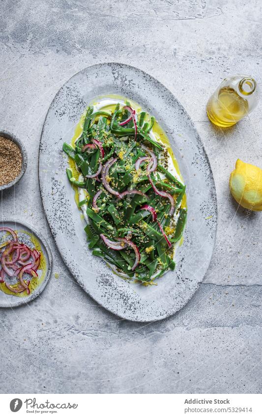 Gesunder Salat mit frischen Kräutern und Zwiebeln auf dem Tisch Salatbeilage Vegetarier Erdöl grün Scheibe dienen Teller Zitrone Speise Lebensmittel Mittagessen