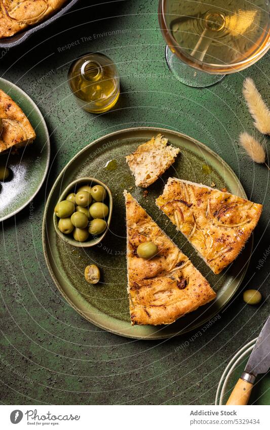 Leckeres Focaccia-Brot mit grünen Oliven auf einem Teller serviert Gabel Messer gebacken Lebensmittel Spielfigur Tradition oliv Ernährung Tisch Ofen Italienisch