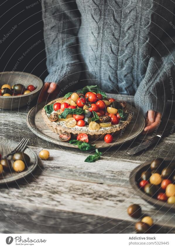 Crop Person mit Flammkuchen, serviert mit Kirschtomaten und Kräutern Torte Tomate Pasteten Teller Kirsche Lebensmittel Gemüse Gesundheit lecker Kraut frisch