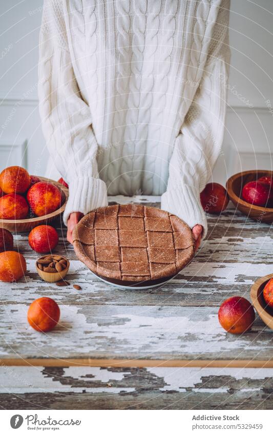 Unbekannte Person mit hausgemachtem Blutorangenkuchen Pasteten gebacken lecker Frucht Veganer Lebensmittel selbstgemacht Tisch essen Dessert süß geschmackvoll