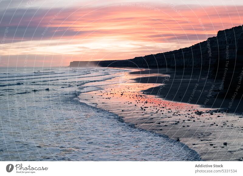 Malerischer Blick auf den Sandstrand bei Sonnenuntergang MEER Meer Natur Strand Berge u. Gebirge Himmel malerisch wolkig wellig Meeresufer Küste Ufer Landschaft