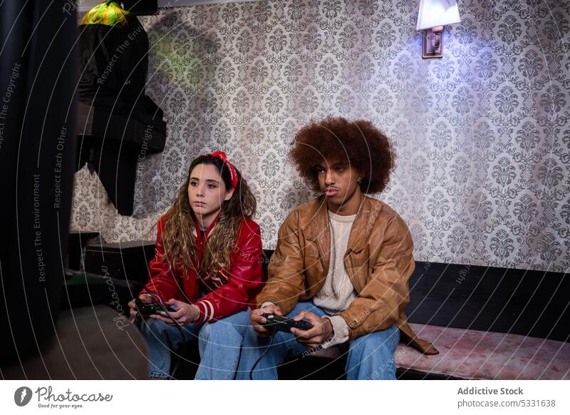 Verschiedene Freunde spielen Videospiele auf dem Sofa Spieler unterhalten Vergnügen Konsole Gamepad Mann Frau Regler männlich benutzend Zusammensein Joystick