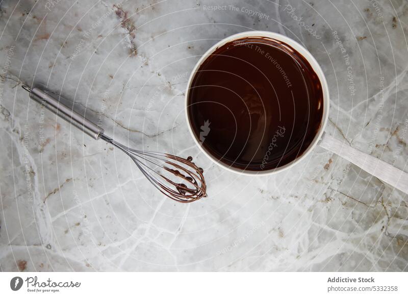 Schokolade im Kochtopf mit dem Schneebesen schmelzen zerlaufen melken Ganache süß Dessert mischen Bestandteil Prozess Küche Murmel Abfertigungsschalter