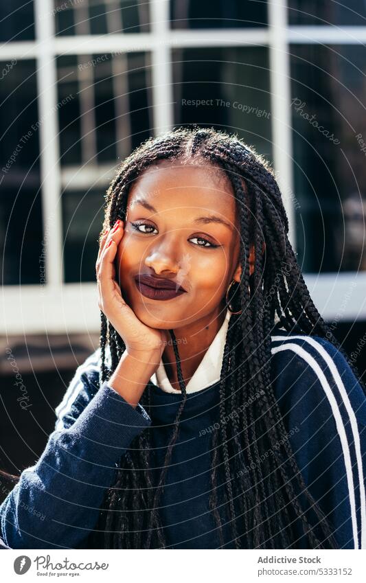 Afroamerikanische Frau mit Afrozöpfen schaut in die Kamera Rastalocken Vorschein Straße Geflecht Porträt starren Starrer Blick Glück positiv Frisur lässig jung