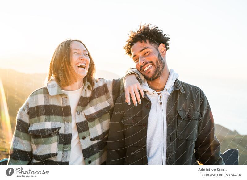 Fröhliches buntes Paar lachend in der Natur Lachen Glück Zusammensein heiter Sonnenuntergang positiv Partnerschaft Liebe Spaß Berge u. Gebirge romantisch Freude