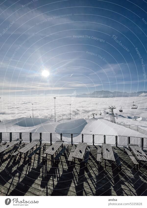 Bergpanorama im Skigebiet mit Hochnebel, Lift und Halfpipe Bänke Café Bank Sitzbank draußen schönes Wetter Sessellift Skilift Skiurlaub Laax Schweiz Graubünden