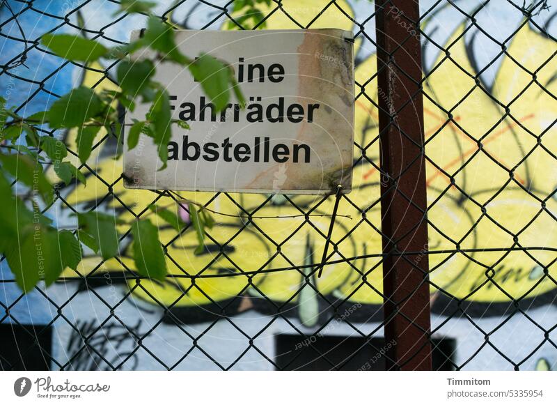 ine Fahrräder abstellen Schild Hinweis Hinweisschild Schilder & Markierungen Schriftzeichen Zaun Blätter grün Graffiti Menschenleer