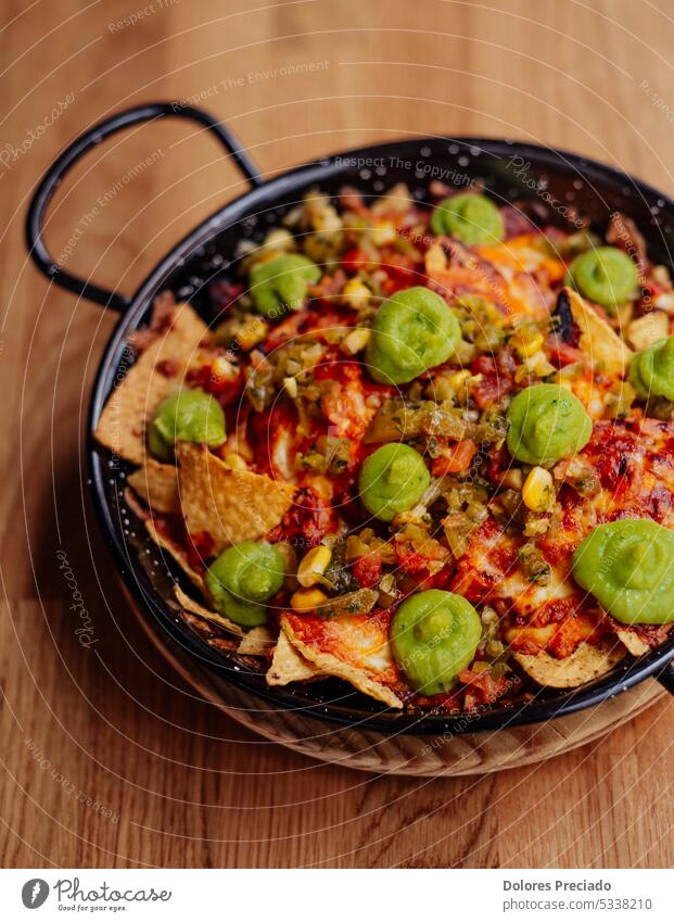 Teller mit Nachos mit Fleisch, Käse und Guacamole Amuse-Gueule Avocado Hintergrund Bier Cheddar Peperoni Chip Chipotle-Pfeffer Mais Mais-Chips Sahne knackig