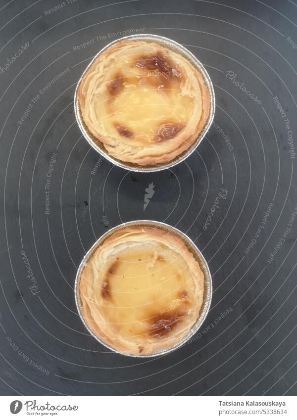 Zwei portugiesische Pasteten Pastel de nata auf einem Steinständer zwei Portugiesisches Gebäck Pastel de Nata Steinstand Dessert Bäckerei traditionell