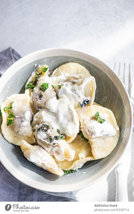 Leckere traditionelle ukrainische Knödel mit Kirsche Lebensmittel Sahne sauer Ukraine Hintergrund gekocht Schalen & Schüsseln Keramik Besteck wüst Speise Gabel