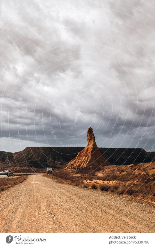 Wüstenstraße in den Bergen unter bewölktem Himmel wüst Straße Berge u. Gebirge Sand Gelände Natur Landschaft wolkig Kamm Ambitus felsig Tal Umwelt leer