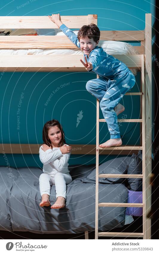 Kinder spielen auf dem Etagenbett im Schlafzimmer bezaubernd Schlafenszeit Geschwisterkind Bett Abend hölzern Laufmasche heimwärts Pyjama Junge Mädchen niedlich