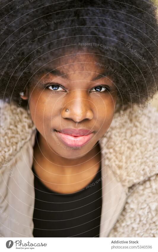 Glückliche ethnische junge Frau mit Afrofrisur Lächeln Afro-Look Porträt positiv froh lange Haare gemütlich Optimist Vorschein Dame Zahnfarbenes Lächeln Freude