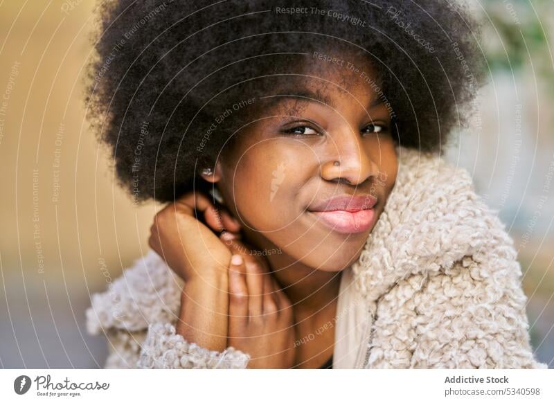 Glückliche ethnische junge Frau mit Afrofrisur Lächeln Afro-Look Porträt positiv heiter froh lange Haare gemütlich Optimist Vorschein Dame Zahnfarbenes Lächeln