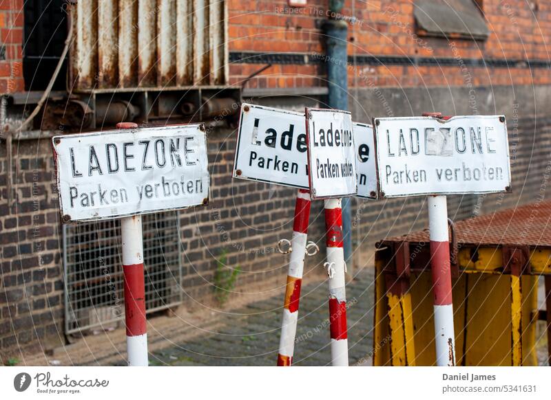 Parkschilder, die draußen aufgestellt sind parken verboten Zeichen Schilder & Markierungen Parkplatz Hinweisschild Wand Warnschild Außenaufnahme Backsteinwand