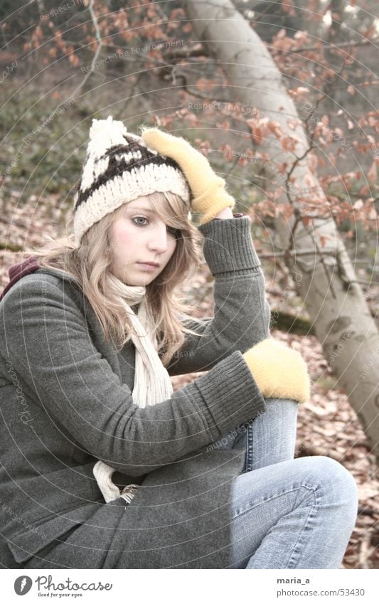 im Wald Frau Baum Blatt Handschuhe Mantel Mütze Schal Herbst Winter kalt Denken blond Baumstamm Jeanshose Tuch sitzen Mensch