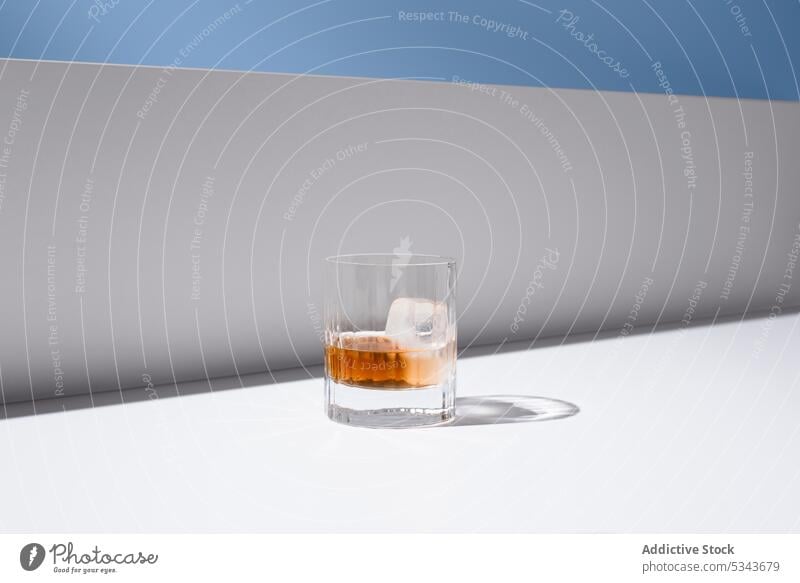 Kristallklares Glas mit erfrischendem Whiskey Eis kristallklar orange kalt Erfrischung trinken Hahnenschwanz durchsichtig liquide Glaswaren geschmackvoll