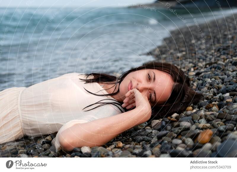 Charmante Frau am steinigen Meeresufer liegend MEER Sommer Ufer ruhen Urlaub Lächeln Lügen Küste winken Glück Strand positiv sich[Akk] entspannen Stein Wasser